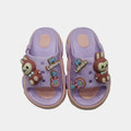 Pair of purple children's sandals with cartoon character design on a light gray background