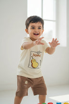 Beige sleeveless top with cartoon design and brown shorts on a white background