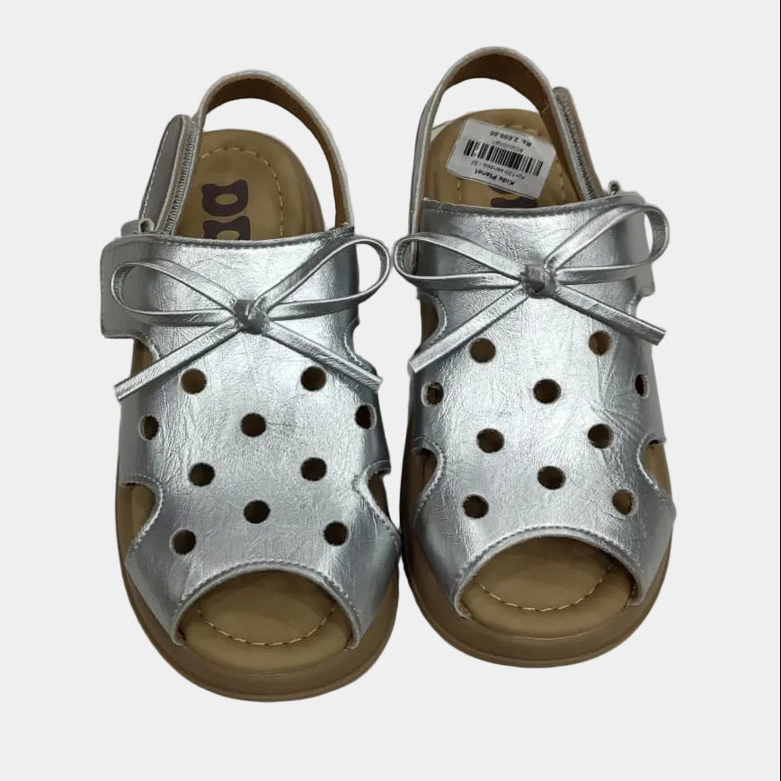 Pair of silver sandals with bow details on a light gray background
