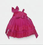 Pink children's dress with ruffles and a bow on a white background