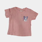 Pink t-shirt with cartoon character on a light gray surface