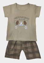 Beige t-shirt with cartoon design and plaid shorts on a light gray background