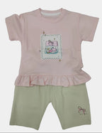 Pink shirt with a cartoon design and beige pants on a white background