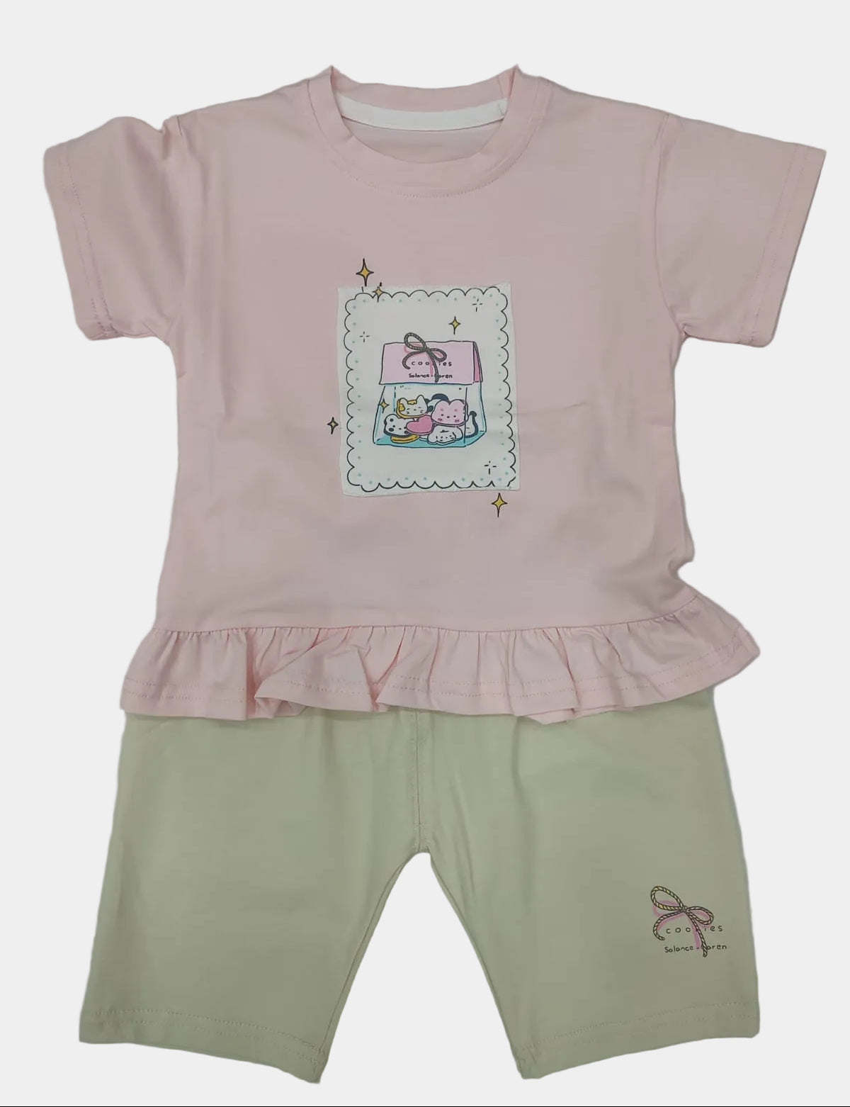 Pink shirt with a cartoon design and beige pants on a white background