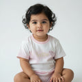 White t-shirt with pink accents and text on a white tiled floor