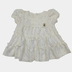 White dress with black polka dots on a light gray background