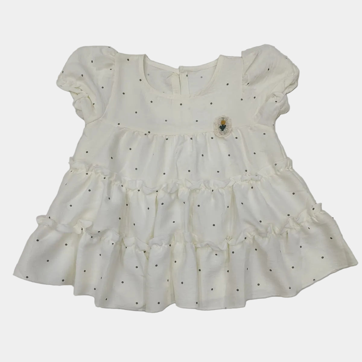 White dress with black polka dots on a light gray background