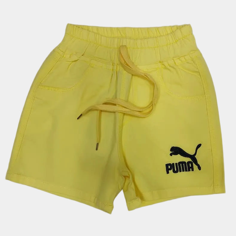 Yellow shorts with a Puma logo on a light gray surface