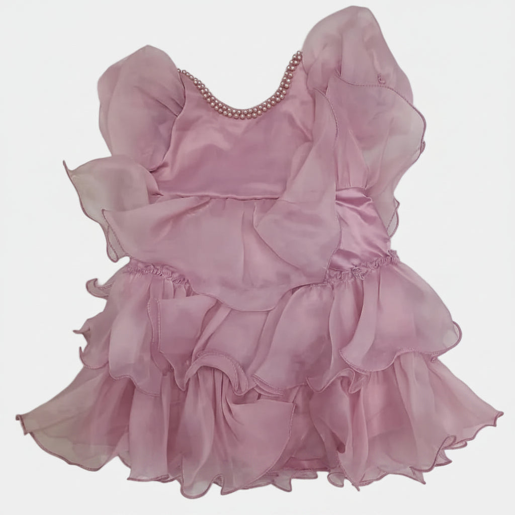 Pink dress with ruffled layers on a white surface