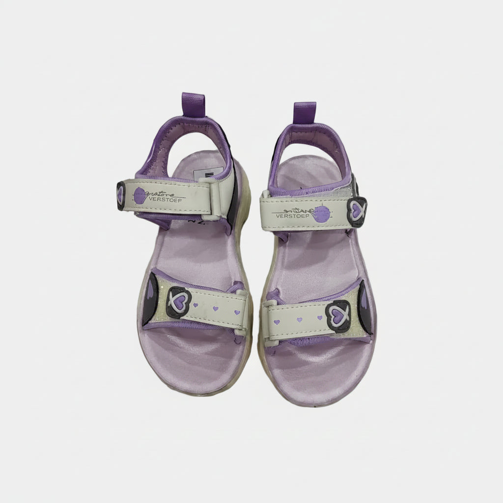 Pair of purple and beige sandals on a light gray background