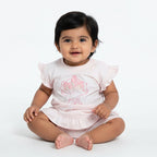 Pink baby outfit with floral design on a light gray surface