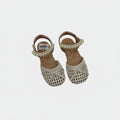 Pair of children's sandals with crochet detailing and pearl embellishments on a light gray background.