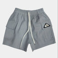 Gray shorts with a logo patch on a light gray background