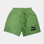 Green shorts with a brand logo on a light gray floor