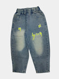 Distressed blue jeans with yellow patches on a white background