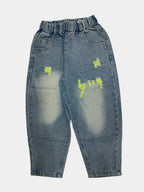 Distressed blue jeans with yellow patches on a white background