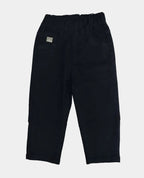Black pants on a white surface with beige pants partially visible