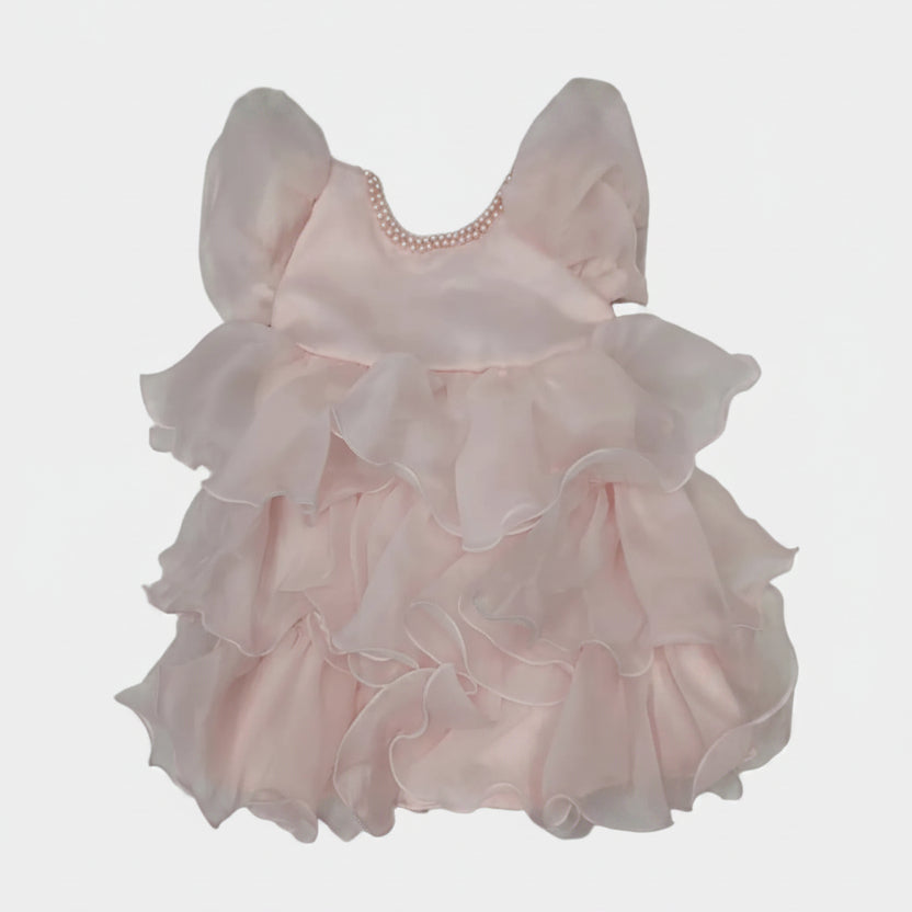 Pink ruffled dress on a white surface
