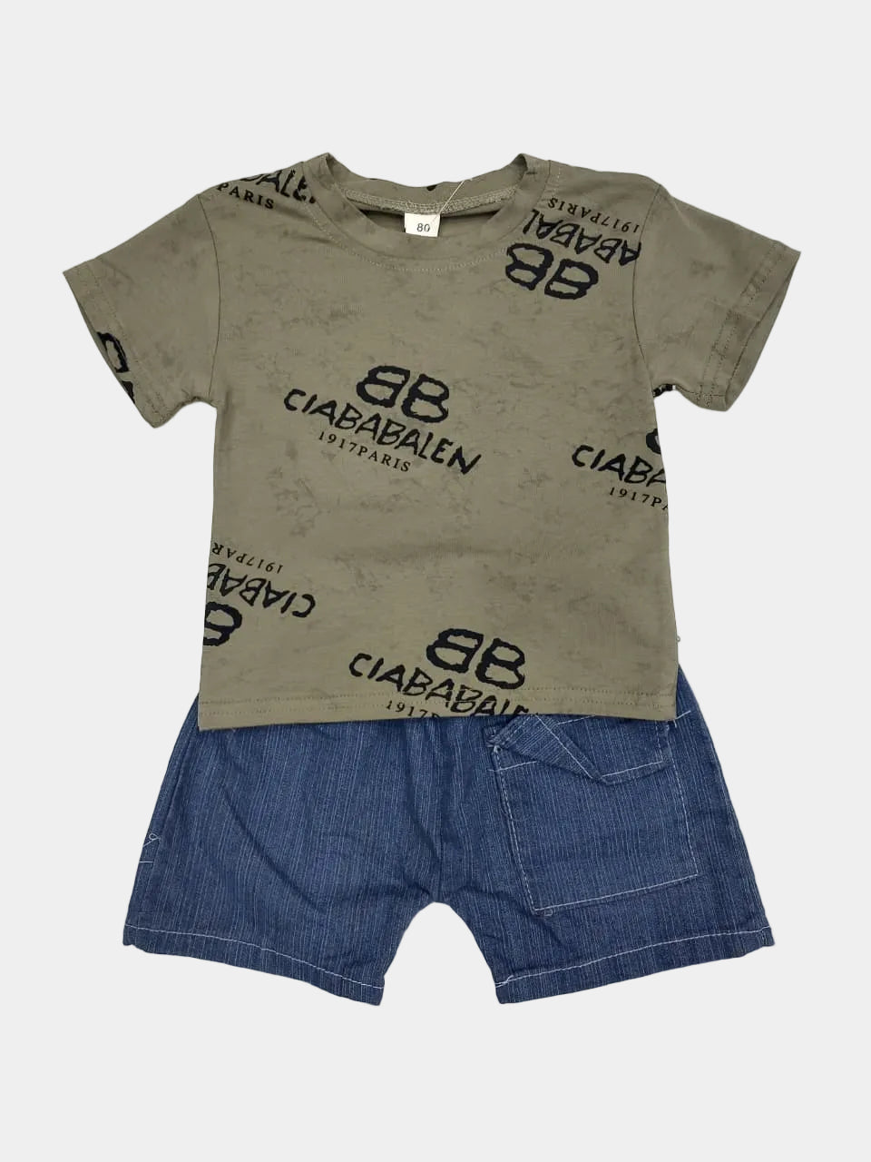 Children's outfit with green t-shirt and blue shorts on a light gray background