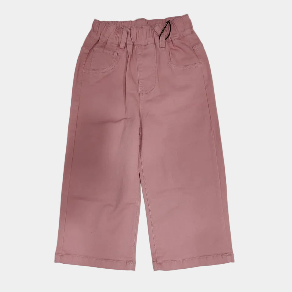 Pink pants on a white surface with black objects around