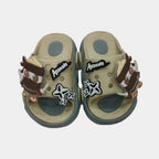 Pair of beige sandals with decorative elements on a light gray background