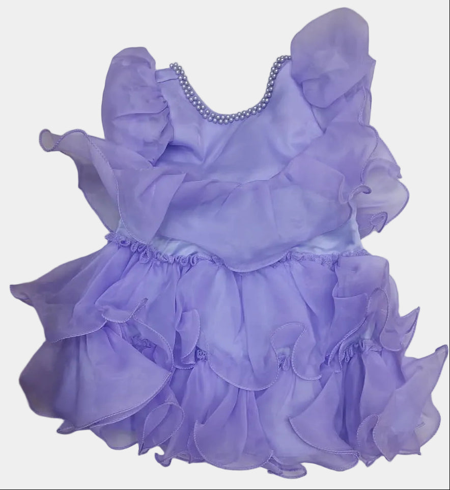 Purple dress with ruffles on a white surface