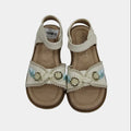 Pair of decorative sandals with embellishments on a light gray background