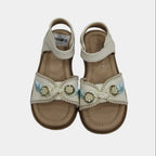 Pair of decorative sandals with embellishments on a light gray background