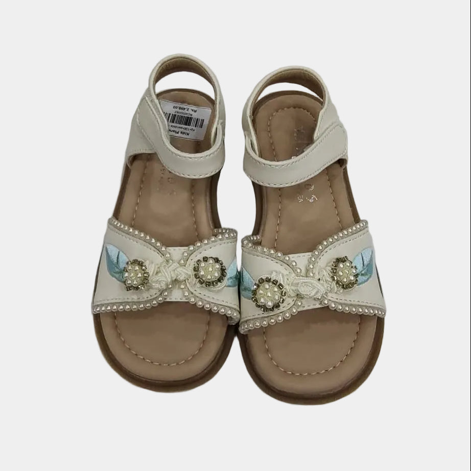 Pair of decorative sandals with embellishments on a light gray background