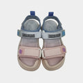 Pair of children's sandals with pink and blue straps on a light gray background