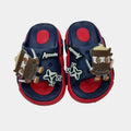 Pair of children's sandals with decorative elements on a light gray background