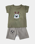 Children's outfit with green t-shirt and beige shorts on a white background