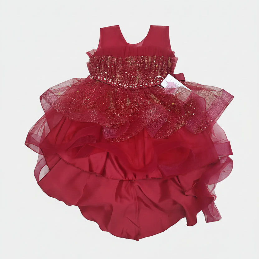 Red baby dress with ruffled layers on a white surface
