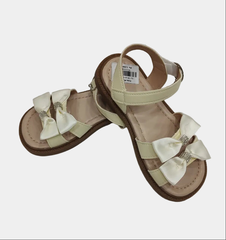 Pair of sandals with bow details on a light gray background