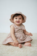 Children's floral dress and hat set on a plain background