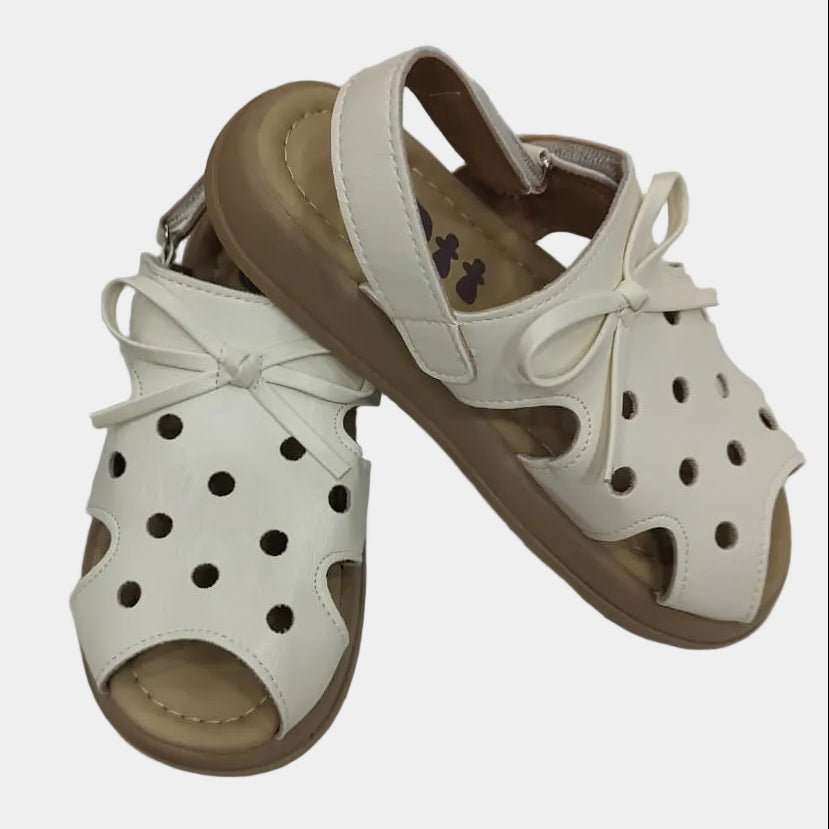 Pair of white sandals with brown soles on a white background