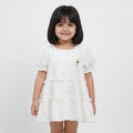 White dress with black polka dots on a light gray background