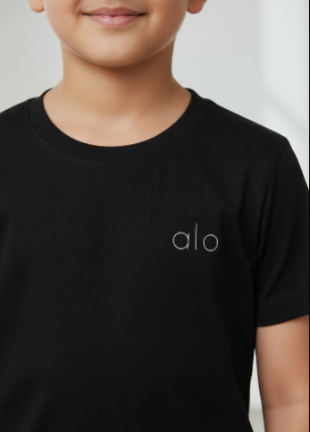 Child wearing a black t-shirt with 'alo' logo on a plain background